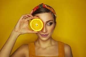 woman holding orange slice in hand