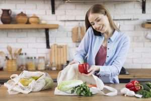 beautiful-young-woman-taking-groceries-out-reusable-bags